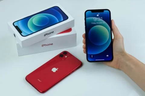 IPhone 12 in blue next to iPhone 11 in red. Stock Photos