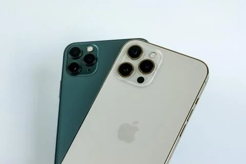 IPhone 12 Pro Max Gold next to iPhone 11 Pro Max in Midnight Green color.  Stock Photos