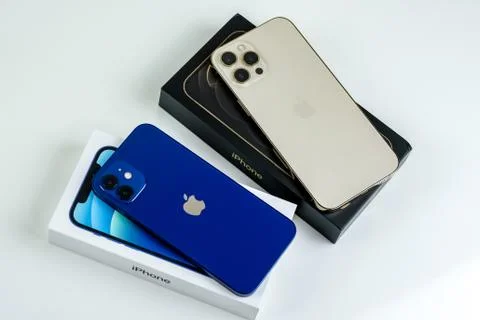IPhone 12 Pro Max in Gold next to iPhone 12 in Blue Stock Photos