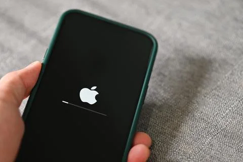 IPhone 13 Pro with apple logo loading and installing operating system ios 15. Stock Photos