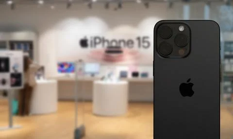 IPhone 15 back side on display in a store selling Apple products. Stock Photos