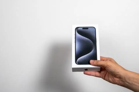 Iphone 15 Pro in a box in the hand on a white background. Demonstrating new Stock Photos