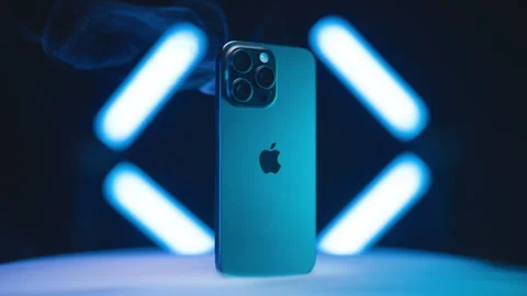 IPhone 15 Pro Max on turntable surrounded with neon lights and smoke 4K Video stock 258265726