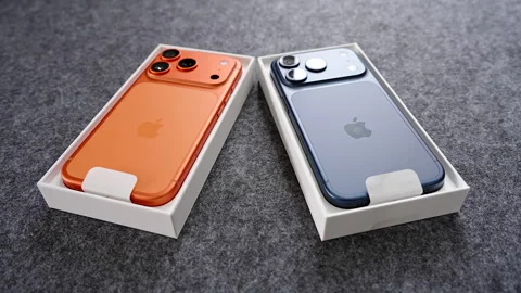 IPhone 17 Pro in Cosmic Orange and Deep Blue Colors Lying Inside Open Boxes on Stock Footage 318050959