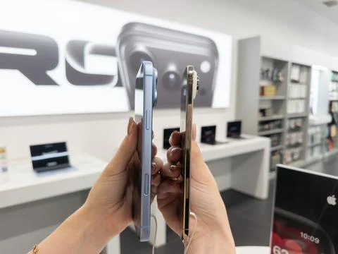 IPhone 18 Pro Glacier and iPhone Air Light Gold held side by side in a retail Stock Photos