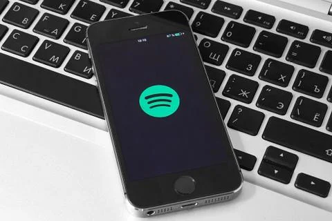 IPhone 5s on laptop with mobile application for Spotify on the screen Stock Photos