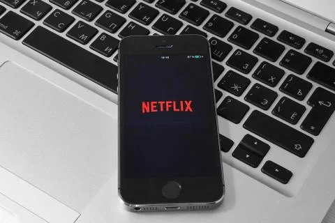 IPhone 5s on laptop with mobile application for Netflix on the screen Stock Photos