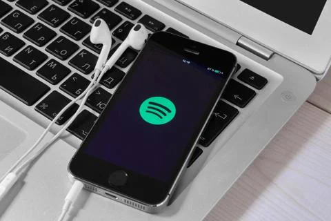 IPhone 5s on laptop with mobile application for Spotify on the screen Stock Photos
