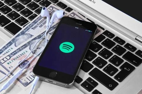 IPhone 5s on laptop with mobile application for Spotify on the screen Stock Photos