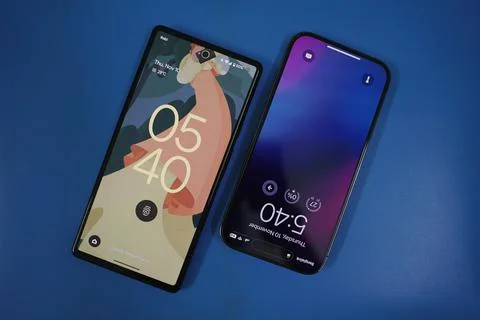 An iphone and a pixel phone a blue background Stock Photos