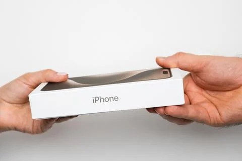 IPhone boxes in womans and mans hands on the white background Stock Photos