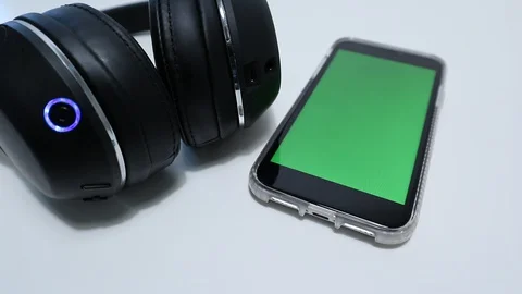 IPhone Connected to Wireless Headphones Greenscreen on smartphone Vidéo 127727073