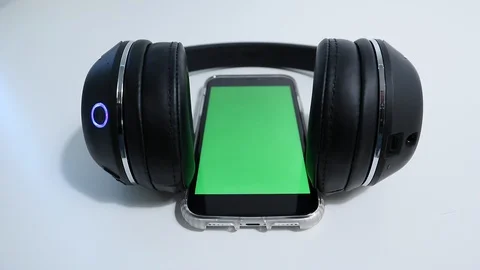 IPhone Connected to Wireless Headphones Greenscreen on phone Vídeos de archivo 127727114
