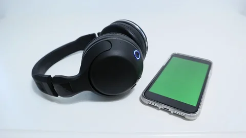 IPhone Connected to Wireless Headphones Greenscreen on phone Video stock 127727121