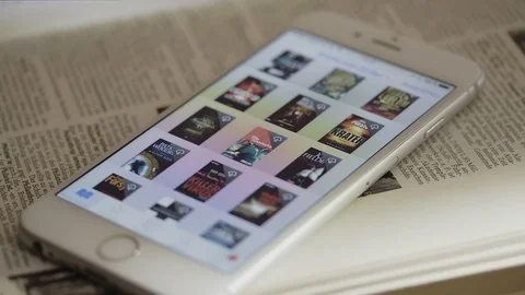 An Iphone with e books on the screen is lying on a old book Video stock 74493615