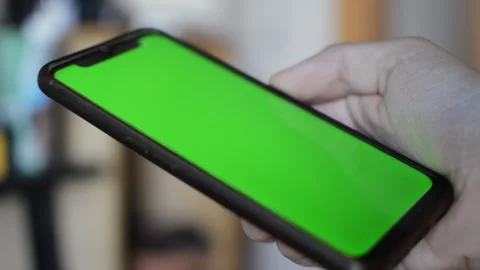 Iphone green screen. young man hold an iphone with green screen display. Video stock 248688172