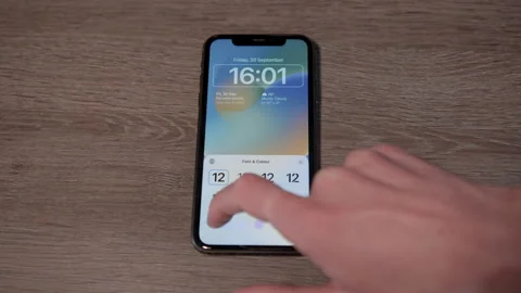 IPhone with IOS 16 customizing lock screen, Medium Stock Footage 217768101
