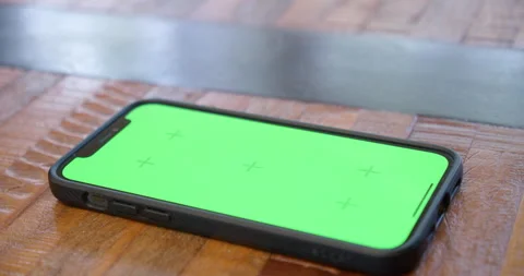 Iphone lying flat on a table, screen displayed in close-up, with green Stock Footage 230123211