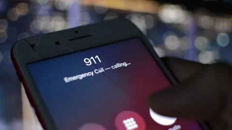 Iphone screen with 911 emergency number on the display in a night city. Stock Footage 238784285