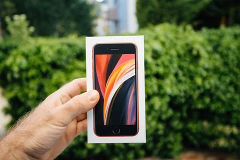 IPhone SE Special Edition 2nd generation in product red color - package against Photos