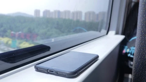 An iPhone sits on the windowsill of a high speed train as it rapidly moves Stock Footage 116858023