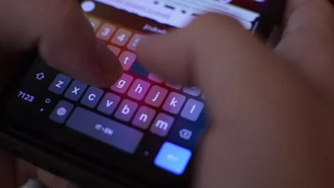 Iphone typing in night blur background. close-up keyboard typing on phone. Stock Footage 249823849