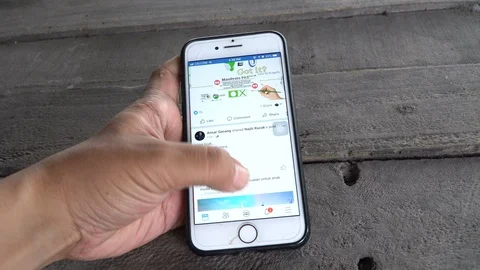 An Iphone user opening and scrolling Facebook Stock Footage 88378633