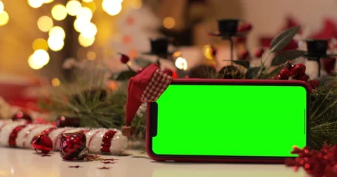 IPhone Xs Max smartphone with pre keyed green screen and Santa Claus' hat on top Stock Footage 144373324