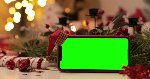 IPhone Xs Max smartphone with pre keyed green screen and Santa Claus' hat on top Stock Footage 144374990