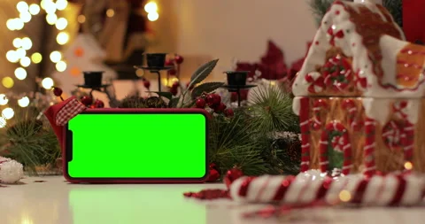 IPhone Xs Max smartphone with pre keyed green screen and Santa Claus' hat on top Stock Footage 144375622