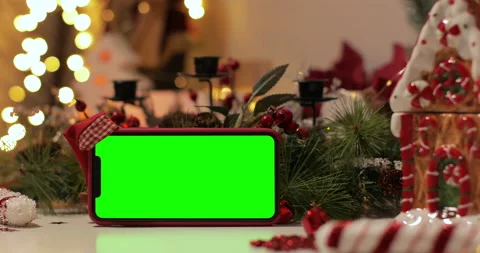 IPhone Xs Max smartphone with pre keyed green screen and Santa Claus' hat on top Stock Footage 144375894