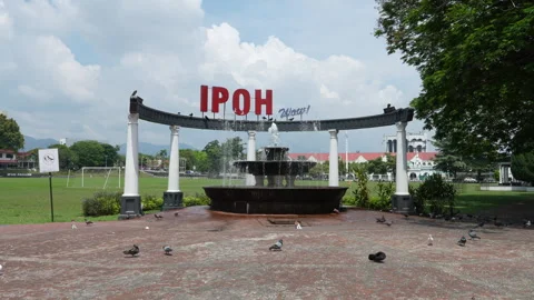 Ipoh Wow sign in front of Ipoh ground. Fountain and pigeons in the foreground. Stock Footage 331724086