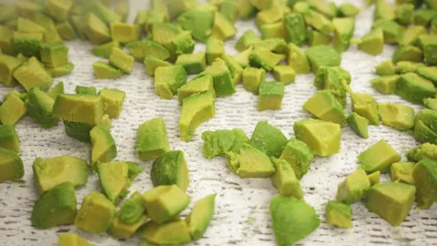 IQF Frozen Avocado Cubes Spreading Out on White Conveyor Surface 스톡 동영상 346738965