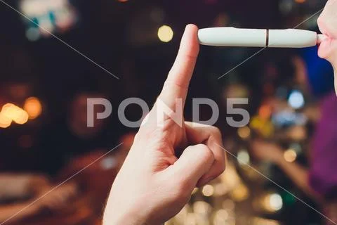 IQOS heat-not-burn tobacco product technology. Man holding e-cigarette in his Stock Photos
