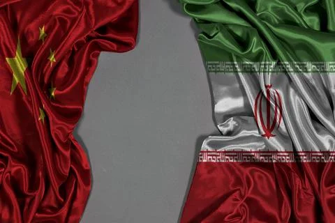Iran And China Flags Side By Side On Silk Fabric Symbolizing Diplomacy And Bilat Stock Photos