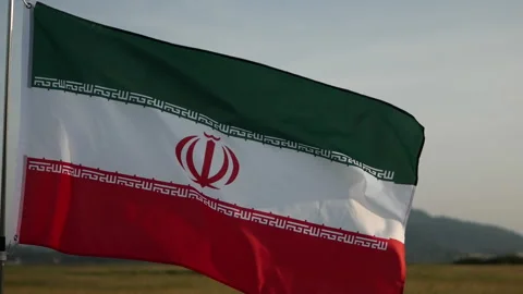 Iran flag waving in the wind against sunset, cloud sky, outdoor background Stock Footage 299963576