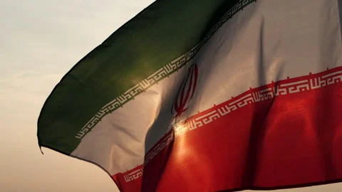 Iran flag waving in the wind against sunset, cloud sky, outdoor background Stock Footage 299963584
