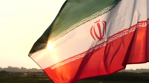 Iran flag waving in the wind against sunset, cloud sky, outdoor background Stock Footage 299963786