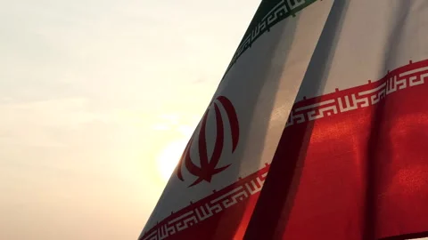 Iran flag waving in the wind against sunset, cloud sky, outdoor background Stock Footage 299963860