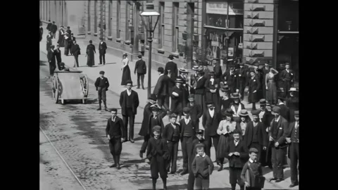 IRELAND - 1901 - People stand at an intersection watching a train go by. Horses Stock Footage 327752040