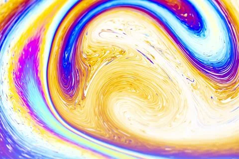 Iridescent soap bubble surface with swirling colors of blue, pink, and gold Fotos Stock