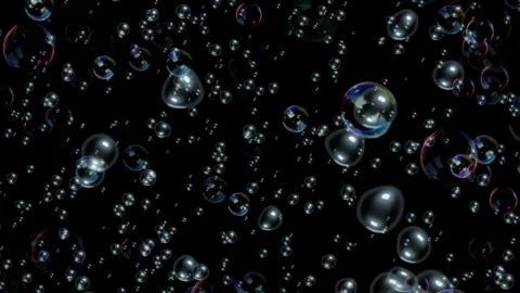 Iridescent soap bubbles floating against a solid black background with soft Stock Footage 346363989