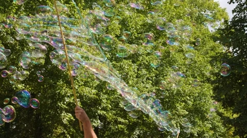 Iridescent Soap Bubbles Floating in a Sunny Berlin Park Stock Footage 326277043