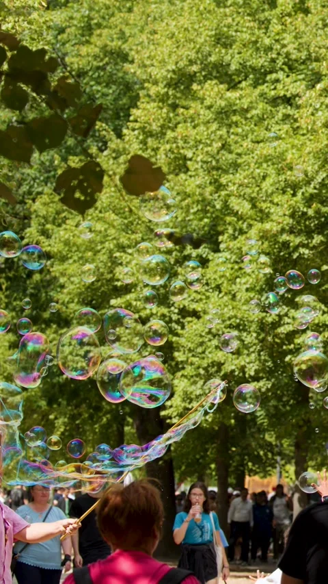 Iridescent Soap Bubbles Floating Through a Sunny Park in Berlin Germany Vídeos de archivo 328079291