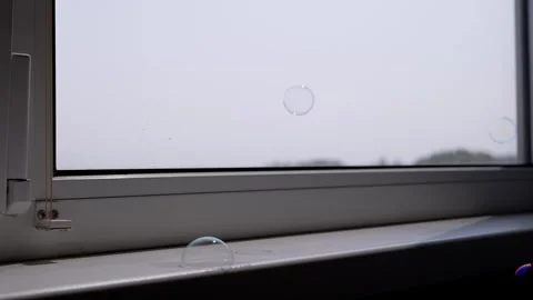 Iridescent Soap Bubbles Gently Pop on Sunny Windowsill Stock Footage 317561374