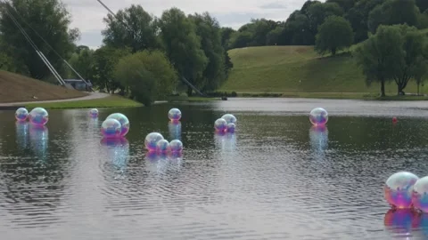 Iridescent Spheres Floating On A Park Lake, Wide Reflection Shot Stock Footage 343022657