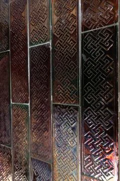 Iridescent surface of patterned tiles forming an geometric design as backdrop Stock Photos