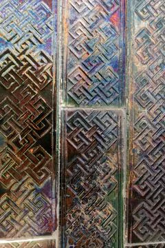 Iridescent surface of patterned tiles forming an geometric design as backdrop Stock Photos