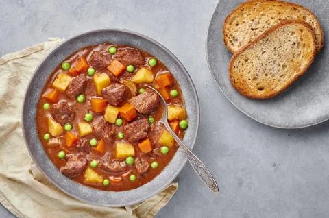 Irish Beef Stew with bread in matt gray bowl on concrete background. Stew wit Stock Photos