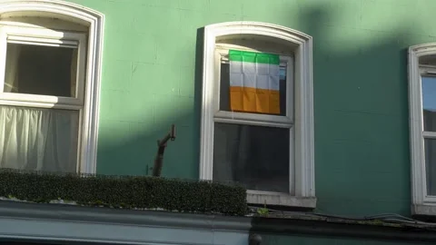 The Irish flag hangs in the window of the green house. Kilkenny. Ireland Stock Footage 236801569